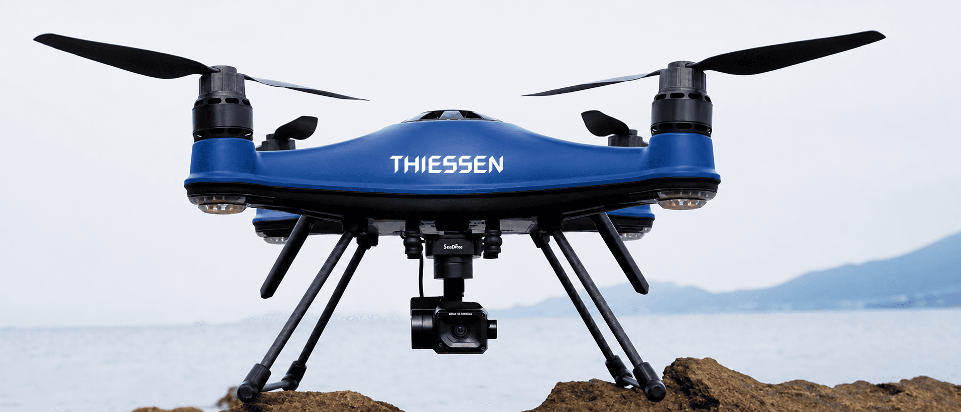 TD3 reference platform — front view on coastal rocks, T3 tri-sensor gimbal visible underneath